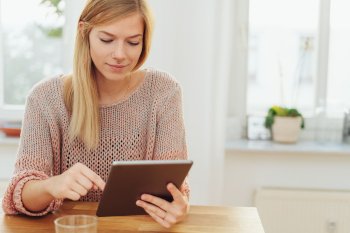 Junge Frau liest auf ihrem Tablet