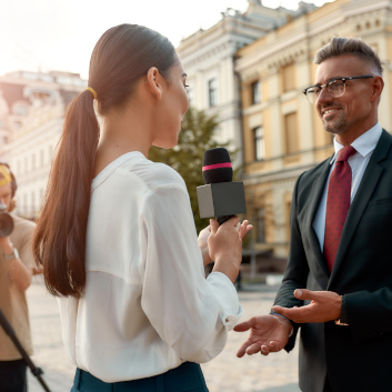 Junge Journalistin führt draußen ein Interview