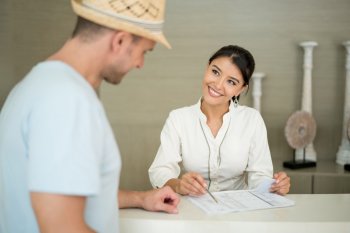 Rezeptionistin erklärt Gast etwas