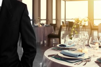 Restaurantmanager steht vor gedecktem Tisch