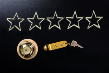 Fünf gezeichnete Sterne mit einem Hotelschlüssel und einer Klingel