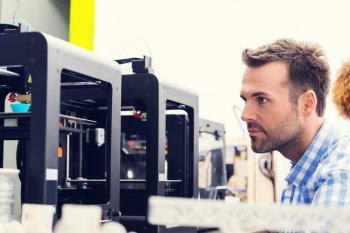 Kunststofftechniker steht an 3D-Drucker