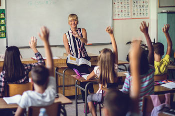 Eine Lehrerin nimmt Schüler dran, die sich melden.