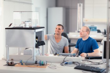 Zwei Mechatronik-Studenten sitzen an 3D-Drucker