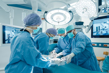 Krankenhauspersonal operiert an einem Patienten in einem OP-Saal.