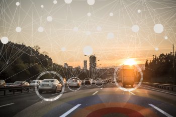 Blick aus Auto auf Autobahn, wo die vorausfahrenden Autos virtuell grafisch vernetzt sind