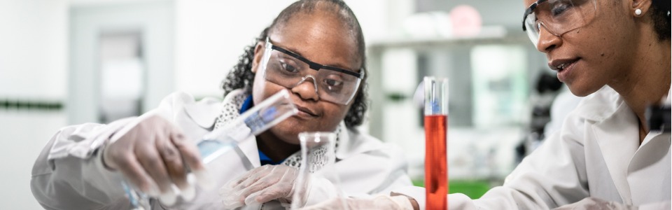 Eine Sonderpädagogin hilft einer Schülerin im Chemieunterricht
