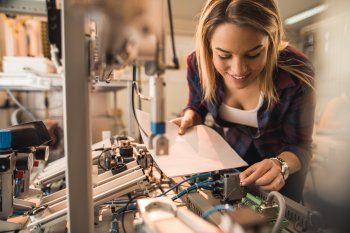 Technologiemanagement Studentin untersucht eine Maschine