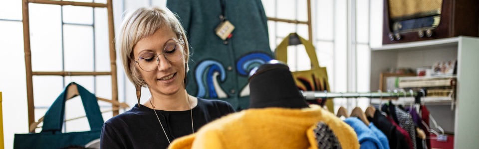 Eine Modedesignerin arbeitet mit einer Schneiderpuppe