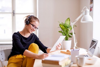 Studentin sitzt am Laptop und schreibt ihre Bachelorthesis