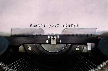 Schreibmaschine mit Text auf Papier "Whats your story?"