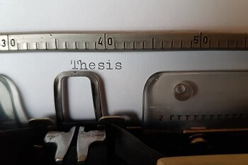 Schreibmaschine mit Papier Aufschrift "Thesis"