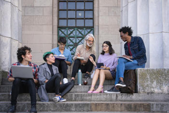 Gruppe von Studierenden auf der Treppe vor einer Uni